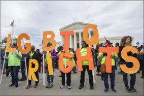  ?? MANUEL BALCE CENETA ?? Supporters of LGBTQ rights hold placards in front of the U.S. Supreme Court, Tuesday, Oct. 8, 2019, in Washington. The Supreme Court heard arguments in its first cases on LGBT rights since the retirement of Justice Anthony Kennedy.