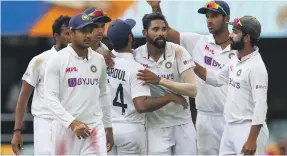  ?? AP ?? A five-wicket haul from Mohammed Siraj, centre, helped India limit Australia to 294 and set up a target of 328 at the Gabba