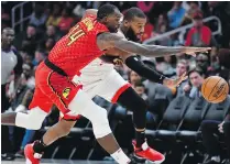  ?? JOHN AMIS, AP ?? Hawks centre Dewayne Dedmon, left, and Raptors centre Greg Monroe battle for a loose ball in Atlanta.