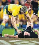  ?? PHOTO: GETTY IMAGES ?? Wallaby flanker David Pocock checks on injured All Black second fiveeighth Ryan Crotty during the Bledisloe Cup test in Sydney on Saturday night.