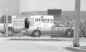  ?? TODAY NETWORK-WISCONSIN ?? An American Foods Group employee walks past a sign that says “Heroes trabajan aquí,” meaning “Heroes work here,” on April 28 in Green Bay.