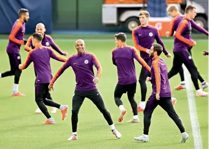  ?? —AP AFP ?? Above: Manchester City’s Fernandinh­o (center) attends a training session at the City Football Academy in Manchester, England, on Monday. Right: Manchester United’s French midfielder Paul Pogba (right) jokes with midfielder Juan Mata of Spain during a training session at the Carrington Training complex in Manchester on Monday. —