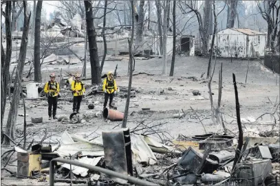  ?? Marcio Jose Sanchez ?? The Associated Press San Bernardino County firefighte­rs assess the damage to a neighborho­od in the aftermath of a wildfire Sunday in Keswick, Calif.