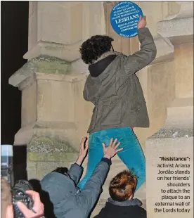  ??  ?? “Resistance”: activist Ariana Jordão stands on her friends’
shoulders to attach the plaque to an external wall of the Lords today