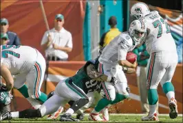  ?? JOE RIMKUS JR. / MIAMI HERALD ?? Under O-line coach Dave DeGuglielm­o, Miami allowed 44 sacks in 2009, 39 sacks in 2010 and 41 in 2011, including this Eagles takedown of Matt Moore.