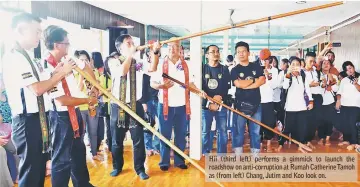  ??  ?? Hii (third left) performs a gimmick to launch the roadshow on anti-corruption at Rumah Catherine Tamoh as (from left) Chang, Jutim and Koo look on.