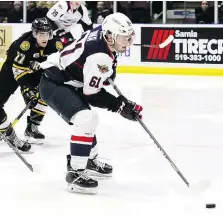  ??  ?? Spitfires’ Luke Boka is pursued by the Sting’s Colton Kammerer in the second period Friday in Sarnia, where Windsor won their second in a row against the Sting, sweeping the home-and-home series with a 7-4 victory.