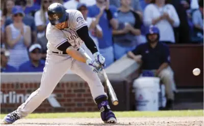  ?? — AP ?? CHICAGO: Colorado Rockies’ Nolan Arenado hits an RBI single against the Chicago Cubs during the seventh inning of a baseball game Friday, in Chicago.