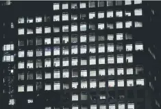  ??  ?? Office lightings are seen through windows of a high-rise office building in Tokyo. Japanese companies are warming to mobilising their mountains of accumulate­d cash for M&amp;A but remain stubbornly resistant to wage increases, a Reuters poll showed on Monday. — Reuters file photo