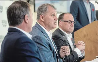  ?? DARREN CALABRESE THE CANADIAN PRESS ?? CFL commission­er Randy Ambrosie, centre, flanked by Maritime Football partners Bruce Bowser, left, and Anthony LeBlanc, says the group doesn’t have to meet an “artificial threshold” for season-ticket deposits.