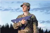  ?? AP ?? Capt. Jennifer Peace holds a flag as she stands near her home in Spanaway, Wash.