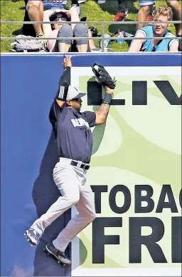  ?? Getty Images ?? GOT IT! Aaron Hicks goes to the warning track to catch a drive by the Astros’ J.D. Davis on Sunday in West Palm Beach, Fla.