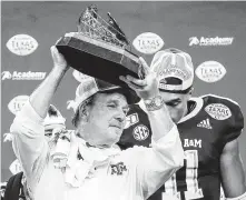  ?? Jon Shapley / Staff photograph­er ?? Texas A&M head coach Jimbo Fisher holds up the Texas Bowl trophy after the Aggies beat Oklahoma State on Friday night.