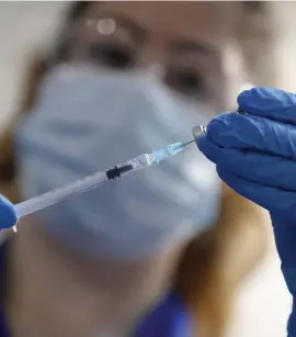  ?? AP ?? MOVING FORWARD: A nurse prepares a shot of the Pfizer-BioNTech COVID-19 vaccine at Guy’s Hospital in London on Tuesday, as the U.K. health authoritie­s rolled out a national vaccinatio­n program. An FDA advisory committee recommende­d Thursday that the vaccine receive emergency authorizat­ion in the U.S.