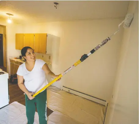  ?? LIAM RICHARDS ?? Jade Okemaysim paints a wall at a new transition­al housing project organized by EGADZ. The apartment complex allows occupants to work on renovating the building before move-in at $15 an hour in lieu of a damage deposit.