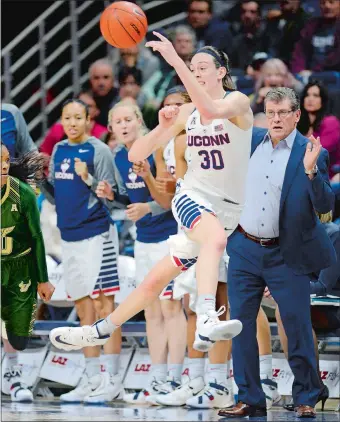  ?? SEAN D. ELLIOT/THE DAY ?? UConn’s Breanna Stewart saves the ball from going out of bounds in front of coach Geno Auriemma and the Husky bench during Monday’s 79-59 victory over South Florida at Gampel Pavilion.
