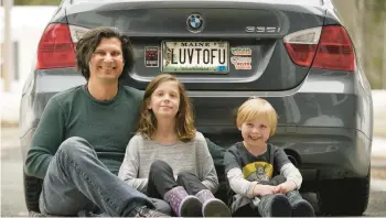  ?? ROBERT F. BUKATY/AP ?? Peter Starosteck­i and his kids Sadie, center, and Jo Jo, pose with the plate Maine deemed inappropri­ate.