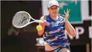  ?? ANDREW MEDICHINI / AP ?? Iga Swiatek of Poland returns the ball to Victoria Azarenka of Belarus during their match at the Italian Open tennis tournament in Rome Thursday.