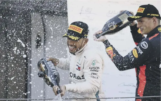  ??  ?? 0 Lewis Hamilton sprays champagne as he celebrates winning the Spanish Grand Prix, along with third-placed Max Verstappen.