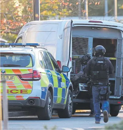  ?? Pictures: AARON CHOWN / PA ?? Swarms of armed police officers surround Bermuda Park in Nuneaton yesterday, where a man armed with a shotgun held two hostages at a bowling alley