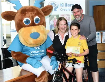  ?? Photo by Michelle Cooper Galvin ?? Karena McCarthy and Rua presenting first prize in the Killarney Credit Union GR8 Saver Schools competitio­n to winner Amelie Counihan with her Dad Marcus at Killarney Credit Union on Friday.