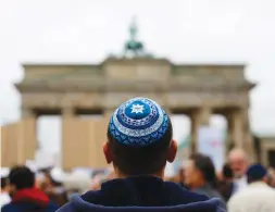  ?? (Thomas Peter/Reuters) ?? A MAN WAITS for the start of a demonstrat­ion against antisemiti­sm, at Berlin’s Brandenbur­g Gate on September 14, 2014.