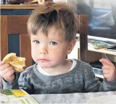  ??  ?? Sticky fingers . . . Ben Rutherford (2) takes a break from gardening to sample a pikelet with Grandma’s homemade raspberry jam.