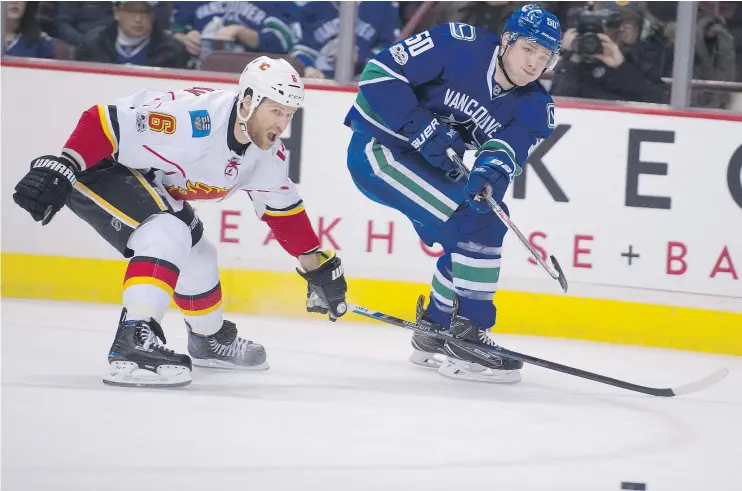  ?? GERRY KAHRMANN/PNG ?? Brendan Gaunce of the Canucks gets a shot past Calgary defenceman Dennis Wideman in the first period of Saturday night’s contest at Rogers Arena.