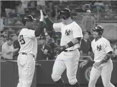  ?? Associated Press photo ?? New York Yankees right fielder Aaron Judge celebrates his two-run home run with Chris Carter (48) and Starlin Castro, right, during the fifth inning of a baseball game against the Chicago White Sox, Monday at Yankee Stadium in New York.