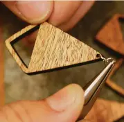  ?? Melissa Phillip / Houston Chronicle ?? John Leslie finishes a pair of wooden earrings that he sells through Amazon Handmade.