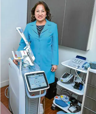  ??  ?? Dr. Editha Dizon with the LightWalke­r laser