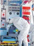  ?? FOTO: DPA ?? Feuerwehrm­ann desinfizie­rt Krankenwag­en – Corona-Alltag in Madrid.