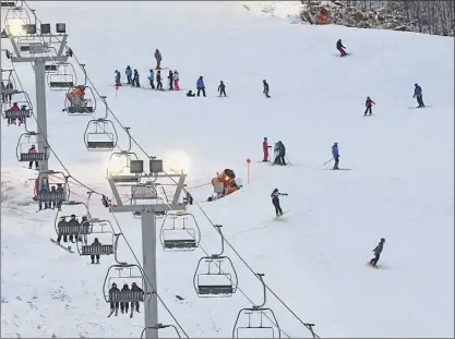  ?? Photos by Lori Van Buren / Times Union ?? Boarders and skiers are seen both coming down a hill and traveling back up on Monday at West Mountain in Queensbury.