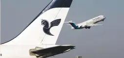  ?? (Morteza Nikoubazl/Reuters) ?? AN ASEMAN AIRLINES Fokker 100 takes off as an Iran Air aircraft is seen in the foreground at Tehran’s internatio­nal airport. Soon Aseman will have a new fleet of Boeing jets.