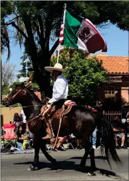  ?? RECORDER PHOTO BY ESTHER AVILA ?? A Mexican Charro brings up the end of the parade participan­ts as he rides along on his horse carrying a dual flag. The flag is the American flag on one side and the Mexican flag on the other side.