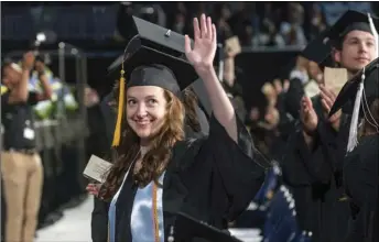  ?? Photo by Michael Derr ?? University of Rhode Island graduate Michaela Healy waves to her friends and family during Saturday’s commenceme­nt ceremony for the College of Arts and Sciences at The Ryan Center.