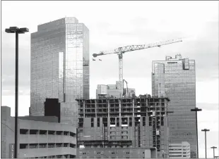  ?? Amanda Mccoy / Fort Worth Star-telegram /TNS ?? A crane can be seen atop what will be Deco 969, the apartment tower under constructi­on in downtown Fort Worth, on Dec. 6, 2022. Deco 969 will have 27 stories of luxury apartments.