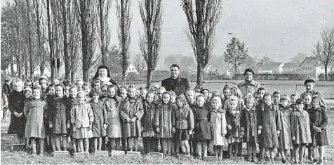  ?? Foto: Fotoalbum Irene Pollack ?? Dießener Kinder kauften Ziegel und Tuffsteine für einen Ring aus kleinen Marterln rund um Dießen. Das Bild aus dem Schuljahr 1955/56 zeigt die Mädchen der 2. und 3. Klasse der Volksschul­e, vor ihnen sieht man einige der Ziegelstei­ne.