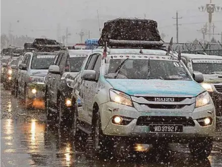 ??  ?? 17 buah kenderaan konvoi terpaksa menempuh laluan bersalji berikutan salji mulai turun ketika peserta mula memasuki bandar raya Almaty.
