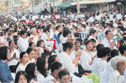  ??  ?? FORGING A NEW START: Villagers join a merit-making ceremony, in which 10,000 monks participat­ed, near the Thao Suranari monument in Nakhon Ratchasima’s Muang district, held yesterday for victims of the mass shooting in the province last weekend.