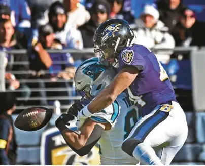  ?? KENNETH K. LAM/BALTIMORE SUN ?? Ravens cornerback Marlon Humphrey, right, breaks up a pass intended for Panthers tight end Tommy Tremble during the second quarter of Sunday’s game at M&T Bank Stadium.