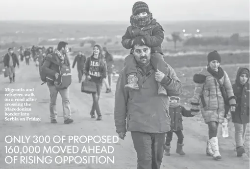  ?? ARMEND NIMANI, AFP/GETTY IMAGES ?? Migrants and refugees walk on a road after crossing the Macedonian border into Serbia on Friday.