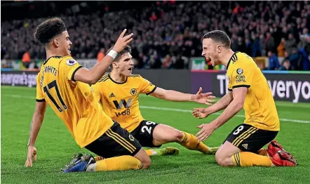  ??  ?? Diogo Jota, right, celebrates with team-mates after scoring Wolves’ second goal in the 2-1 win over Chelsea yesterday.