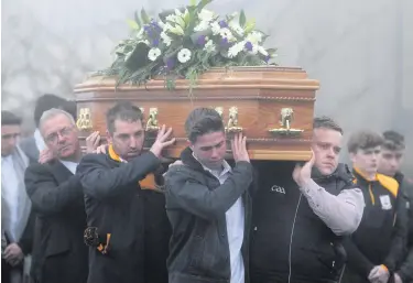  ??  ?? Mourners carry the coffin of father-of-two Christophe­r Colhoun in Clonoe, Co Tyrone, yesterday