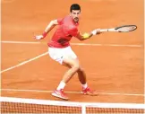  ?? ?? Novak Djokovic returns the ball to Diego Schwartzma­n