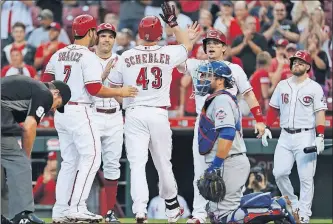  ?? [JOHN MINCHILLO/THE ASSOCIATED PRESS] ?? The Reds’ Scott Schebler celebrates with Eugenio Suarez, left, Joey Votto, second from left, and Scooter Gennett after hitting a grand slam in the first inning.