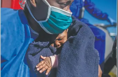  ??  ?? Sandrine, 33, from Cameroon holds her 3-month-old son, Moise, moments before leaving the Spanish NGO Open Arms rescue vessel in the Sicilian port of Empedocle, Italy.