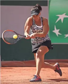  ?? JULIAN FINNEY, GETTY IMAGES ?? Casey Dellacqua hits a shot during a French Open doubles match. She and Ashleigh Barty advanced to the second round.