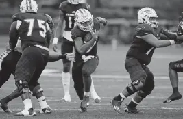  ?? JOHN MCCALL South Florida Sun Sentinel ?? Chaminade-Madonna running back Davion Gause, who scored three touchdowns, carries the ball against American Heritage during the first half on Friday night.