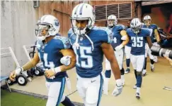  ?? THE ASSOCIATED PRESS ?? Tennessee Titans wide receiver Eric Weems (14) and wide receiver Darius Jennings (15) walk to the field with arms linked after the national anthem had been played before their Sunday game against the Seattle Seahawks in Nashville. Neither team was...